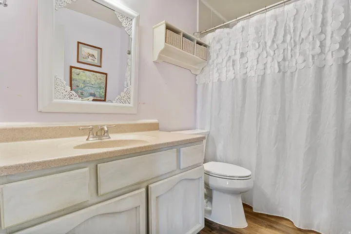 Bathroom featuring a single-sink vanity with a light-colored countertop, brushed nickel faucet, and a white framed mirror