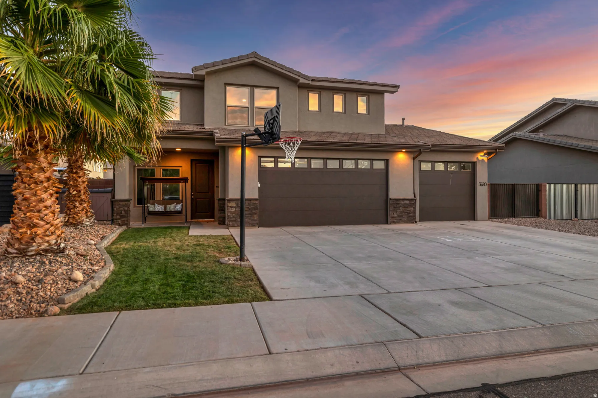 Modern two-story residence featuring a striking contemporary exterior with charcoal-toned siding and stone accents