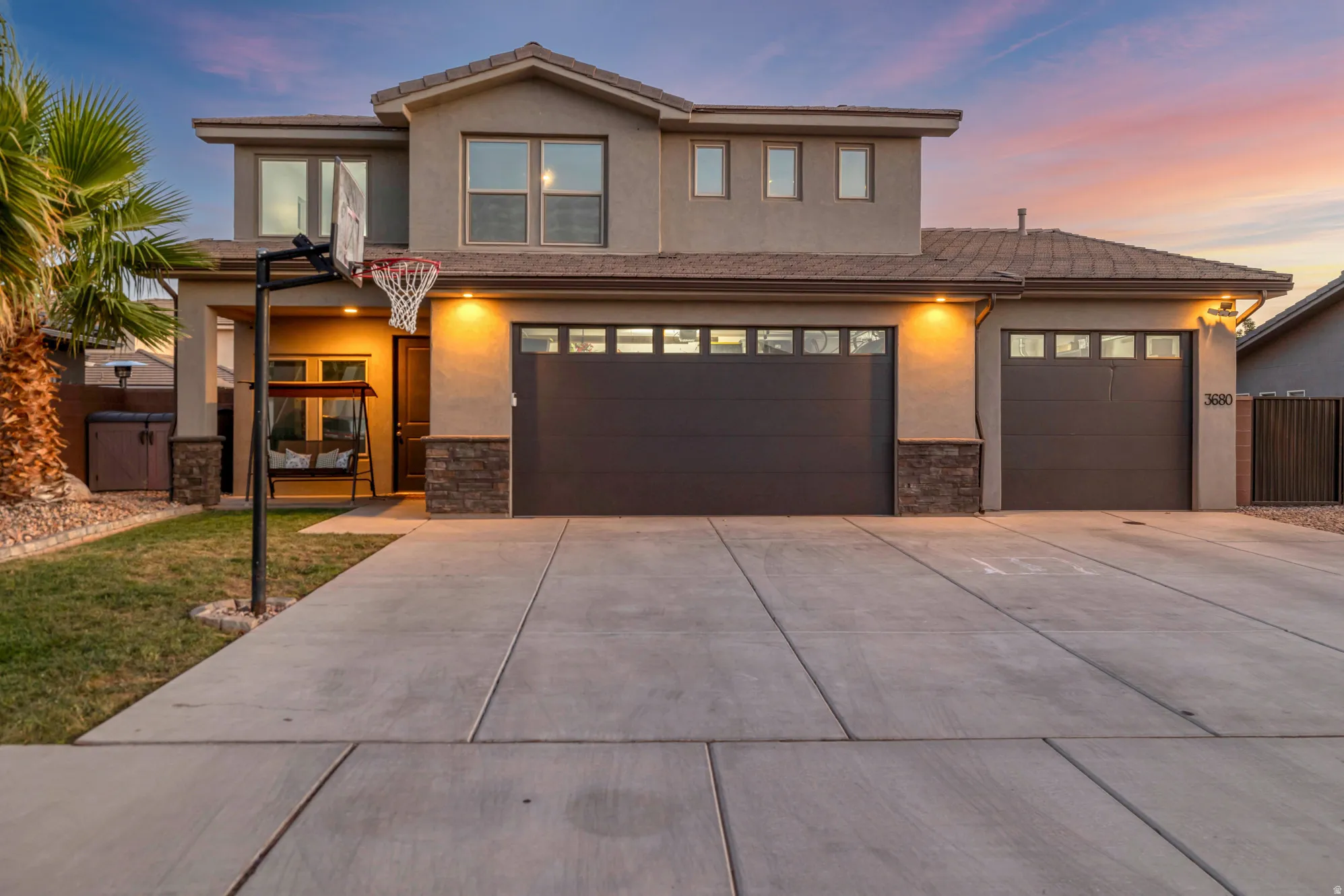 Contemporary stucco residence featuring a multi-car driveway, an integrated two-car garage, and an additional single-car garage
