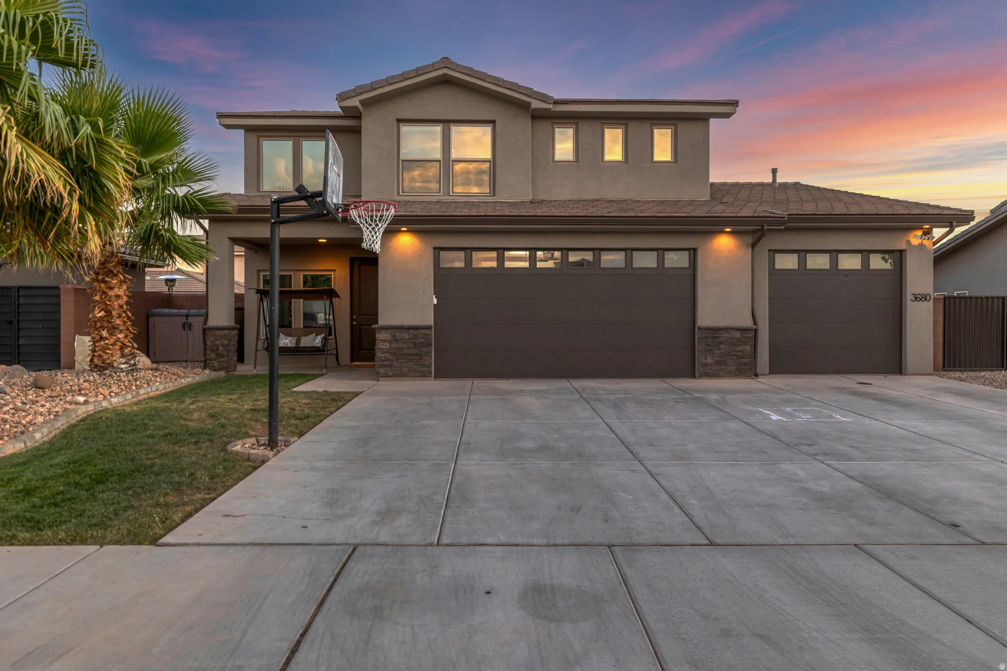 Two-story residence featuring a neutral-toned stucco exterior and a tile roof
