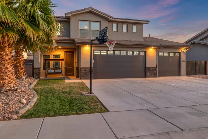Contemporary two-story stucco exterior featuring stone accents and a multi-car garage