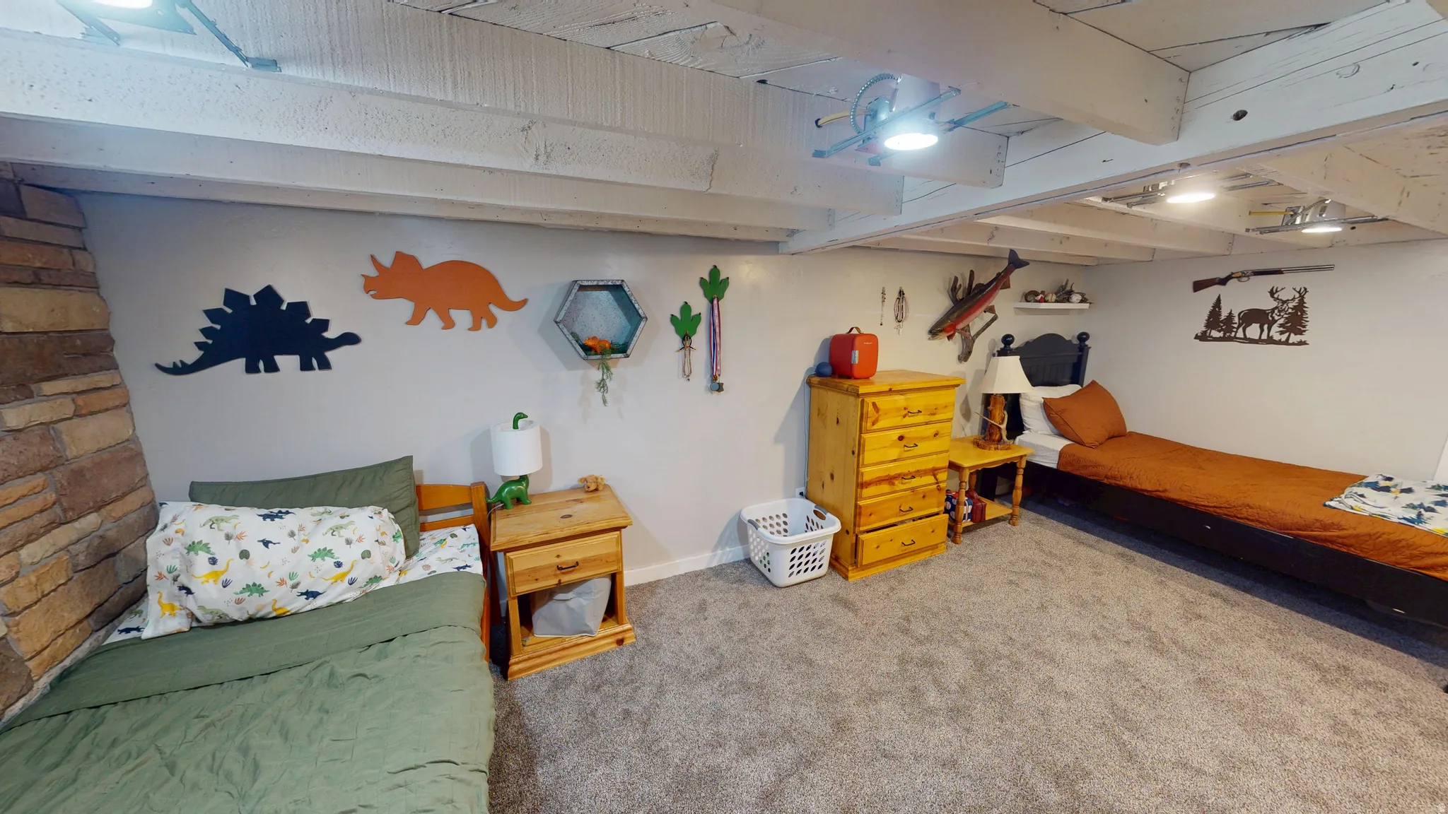 Spacious room featuring exposed white-painted ceiling beams, light gray wall paint, and gray carpeted flooring