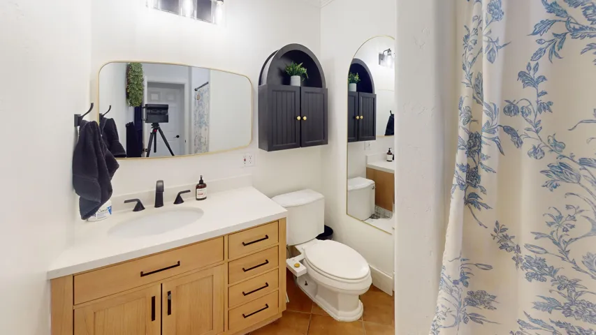 Bathroom featuring a wood-finish vanity with a white countertop and integrated sink