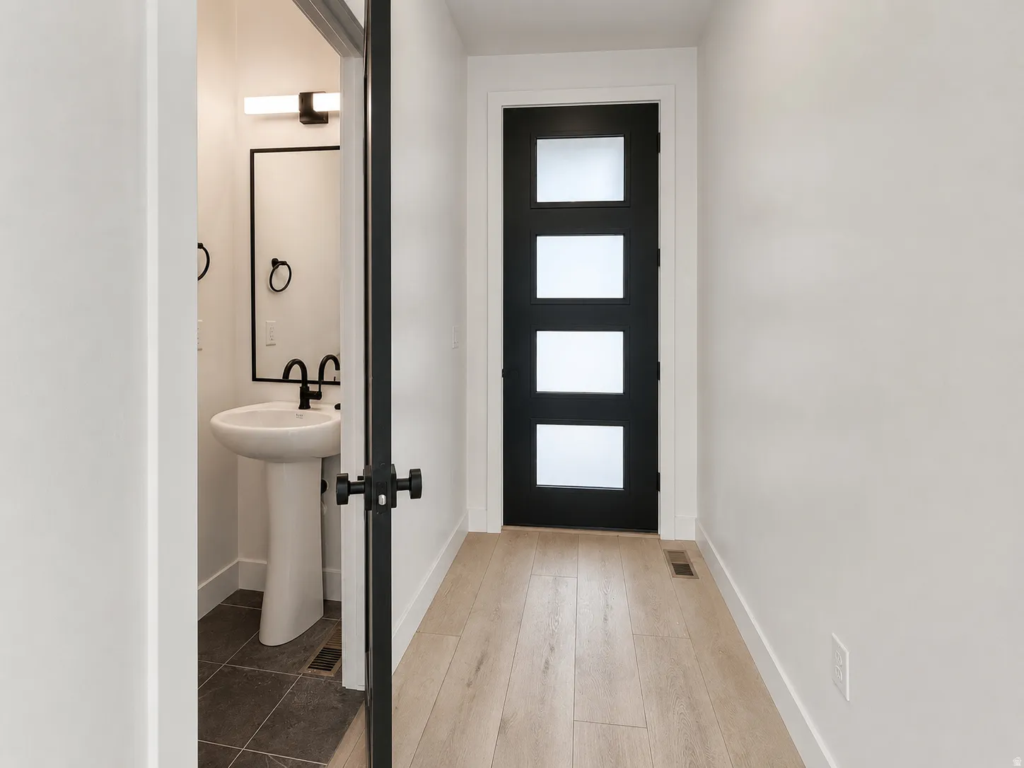 Hallway featuring light wood-finish flooring and white walls