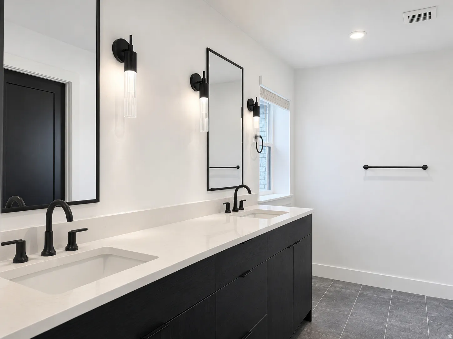 Double vanity featuring white countertops, undermount sinks, and matte black fixtures