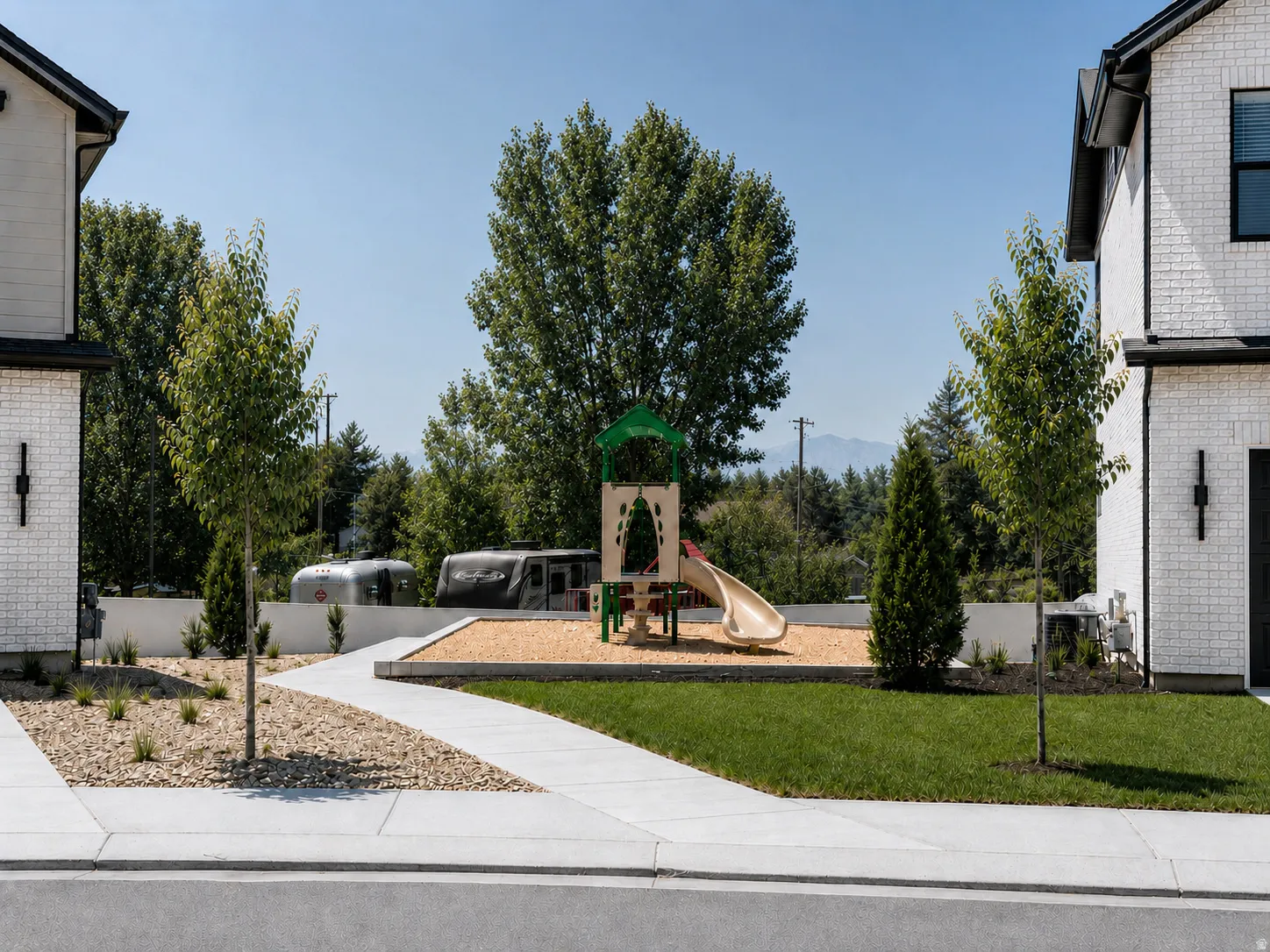Community playground featuring a slide, climbing elements, and wood chip base