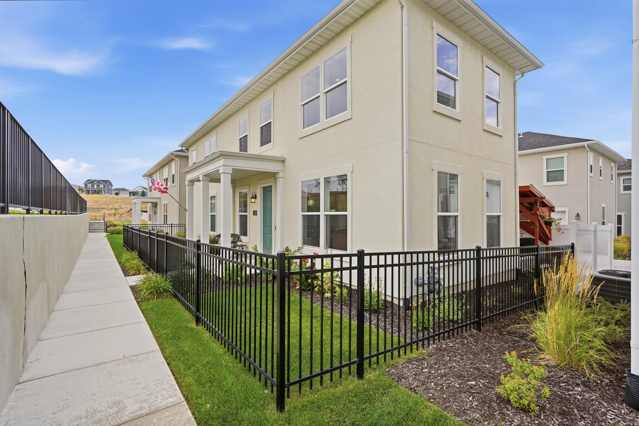 Fully fenced yard with grass and flowers
