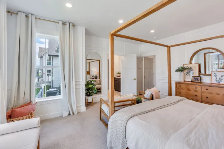 Carpeted bedroom featuring recessed lighting, a large window with white trim, and architectural wall paneling