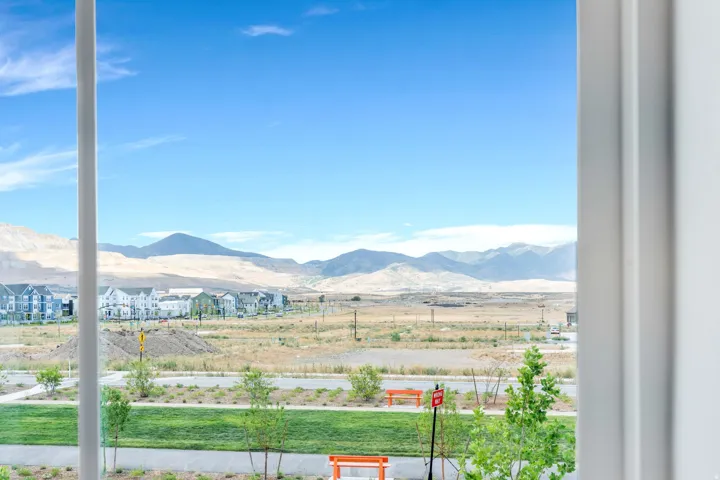 Expansive mountain range backdrop framing a neighborhood with contemporary residential architecture