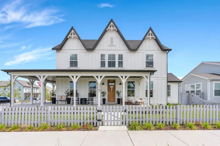 White board-and-batten siding with dark trim accents and multiple gables