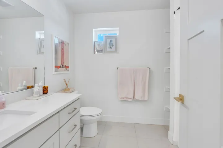 Contemporary bathroom with a single vanity, a rectangular sink, and light-colored countertops