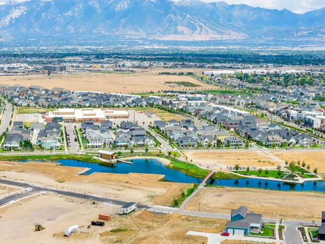 Expansive aerial view showcasing a developing residential community with a large body of water