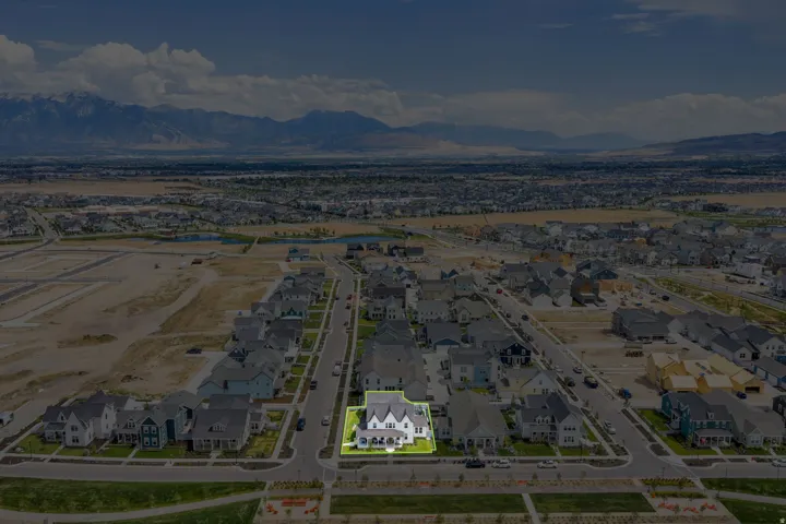 Aerial perspective showcasing a residential street with single-family homes and a distant mountain range backdrop