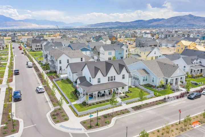 Modern suburban neighborhood featuring a variety of architectural styles, manicured lawns, and tree-lined streets