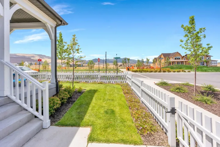 Covered porch entry featuring concrete steps, white railings, and a metal roofline