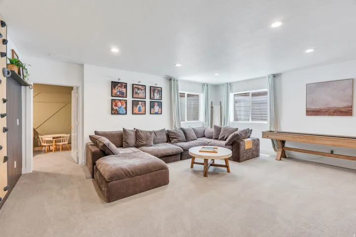Spacious carpeted room featuring recessed lighting, multiple windows, and a built-in wall feature
