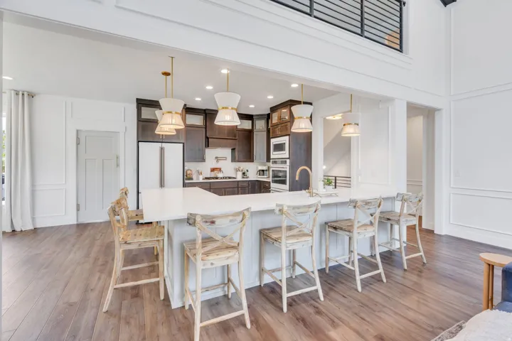 Kitchen island with white countertop, integrated sink, and gold-finish faucet