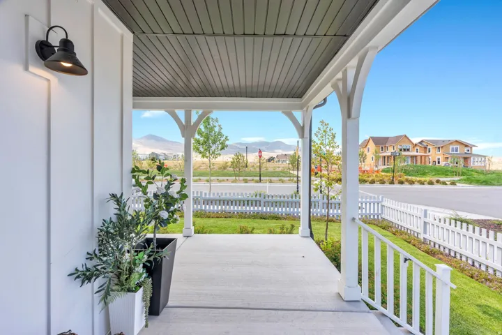 Covered front porch with concrete flooring and white railing