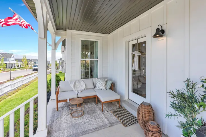 Inviting front porch featuring white vertical siding, a paneled ceiling, and a glass-paned entry door