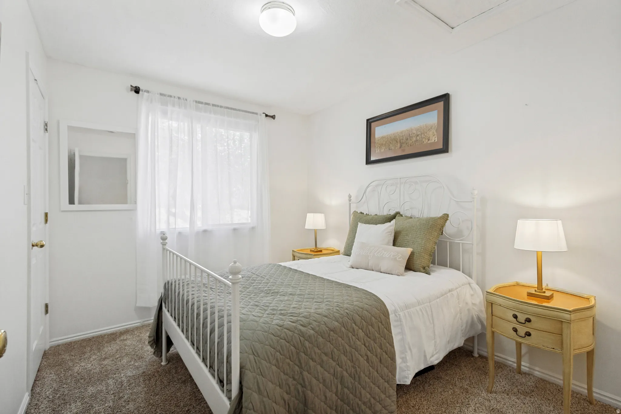 Bedroom featuring wall-to-wall carpeting, a large window with sheer curtains, a flush-mount ceiling light, and white painted walls