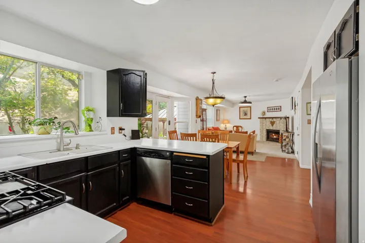 Kitchen featuring dark cabinetry, white countertops, stainless steel appliances, and a gas range