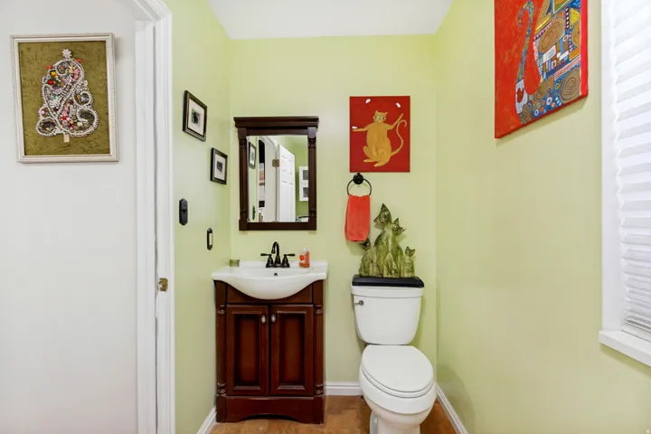 Powder room featuring a single vanity with dark wood-finish cabinetry, white basin, and matte black faucet