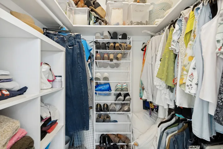 Well-organized closet featuring built-in shelving, hanging rods, and an integrated shoe rack