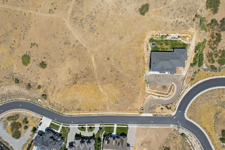 Newly constructed residence featuring a dark gray shingle roof, an attached garage, and a private driveway