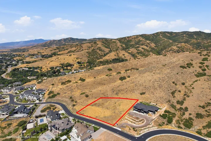 Expansive developable lot with paved road frontage, surrounded by natural mountainous terrain