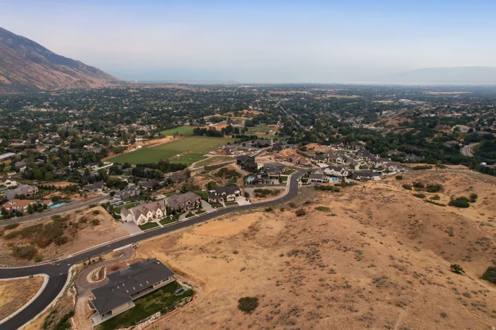 Aerial perspective of an expansive residential development featuring a newly paved roadway and multiple properties