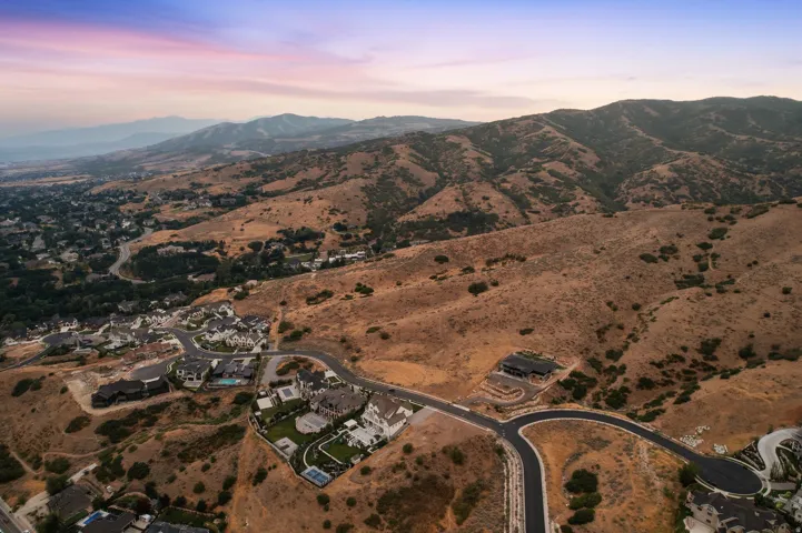 Hillside community featuring residential properties, paved roads, and extensive natural landscape