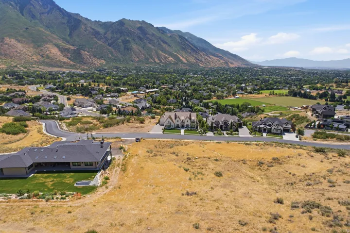 Expansive property featuring a contemporary ranch-style residence with a dark shingle roof and a manicured lawn