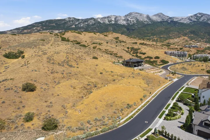 Mountainous terrain providing a natural backdrop to a residential development featuring paved roads and modern homes