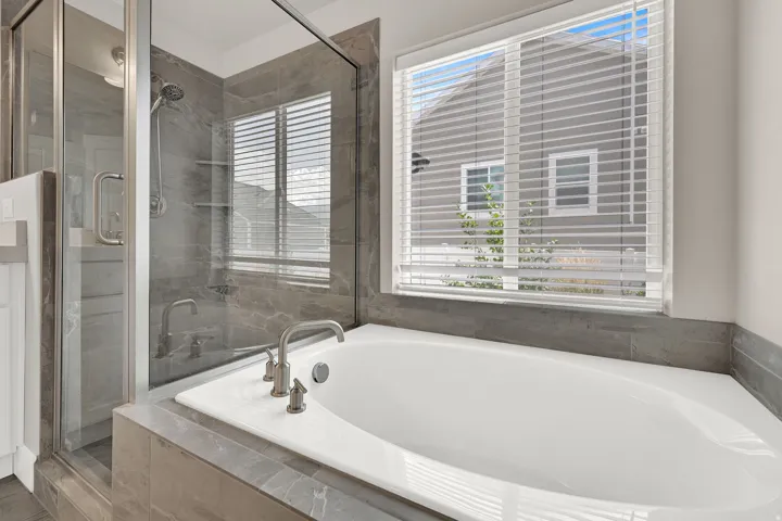 Soaking tub with brushed nickel fixtures set into a tiled surround