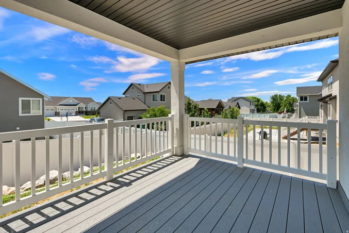 Covered outdoor patio featuring composite decking, a white railing system, and a textured ceiling