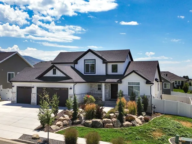 Contemporary residence featuring a white and dark gray exterior with stone accents