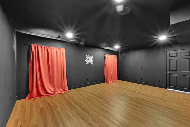 Interior space featuring wood-finish flooring, dark-painted walls, and a dark-painted ceiling