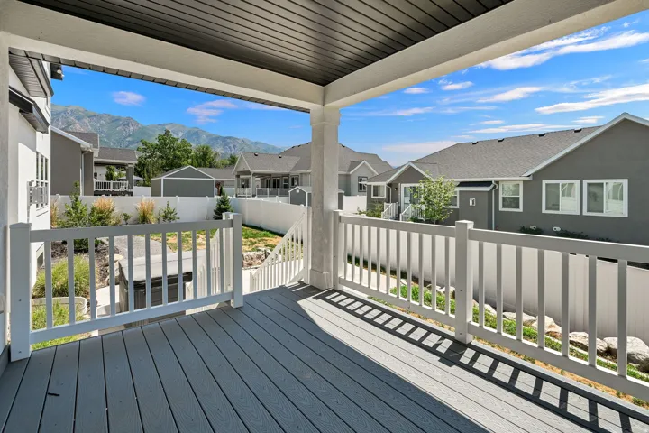 Covered patio featuring composite decking and white railings
