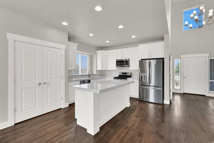 Kitchen with white cabinetry, light countertops, and stainless steel appliances