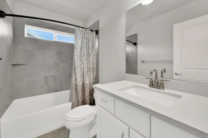 Bathroom featuring a white vanity with an integrated sink and light-colored countertop