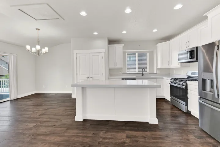 Open-concept kitchen and dining area featuring wood-finish flooring
