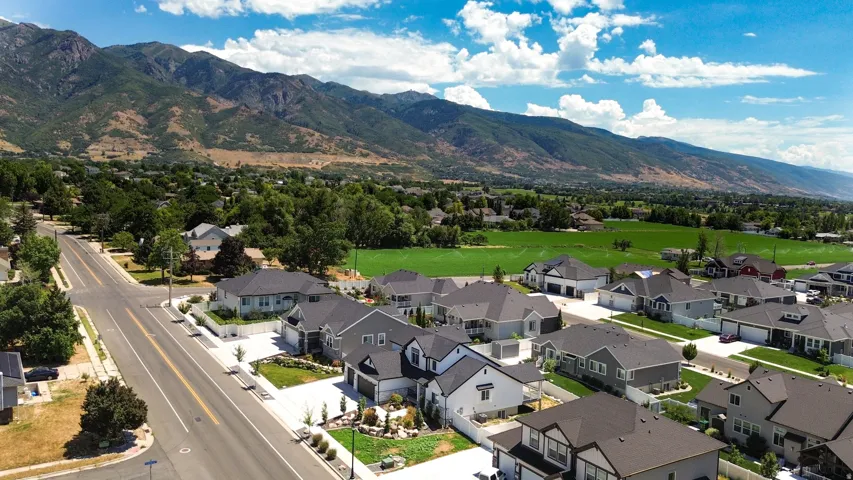 Residential neighborhood featuring varied single-family homes with dark shingled roofs and landscaped front yards