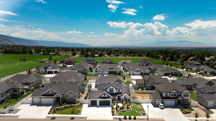 Expansive residential development featuring modern homes with dark roofs and light-toned exteriors