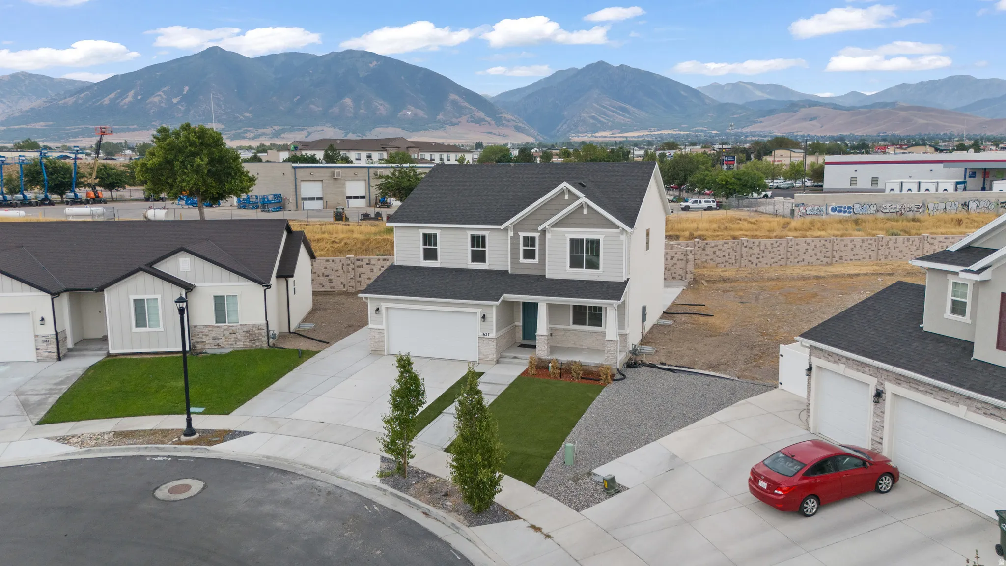 Two-story residence with light gray siding and dark roof shingles