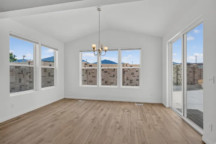Spacious room featuring vaulted ceilings and wood-finish flooring
