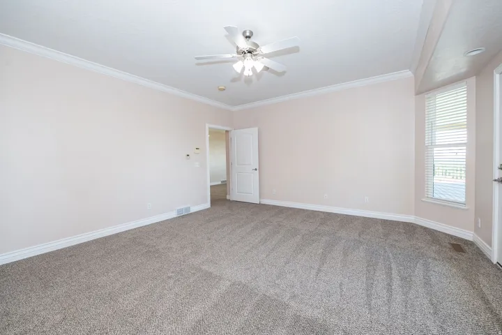 Spacious room featuring neutral carpeting and light-toned walls