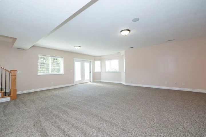 Spacious room featuring neutral carpeting and light-toned wall paint