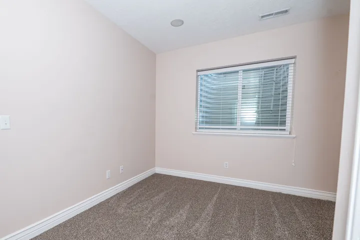Room featuring neutral wall tones, white trim, and light brown carpeting