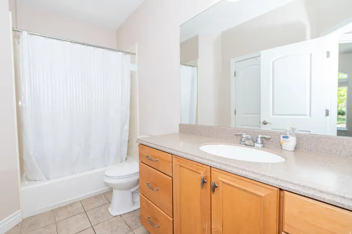Bathroom vanity featuring a light-toned countertop, integrated sink, and chrome faucet
