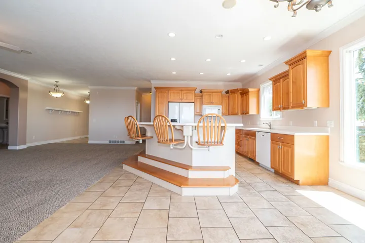 Spacious kitchen featuring wood cabinetry, light-toned countertops, and integrated appliances